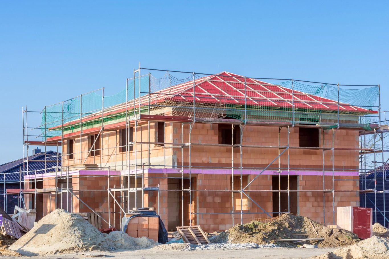 Massivhaus bau Neubau eines Hauses mit Baugerüst und unvollständigem Dach in ländlicher Umgebung.