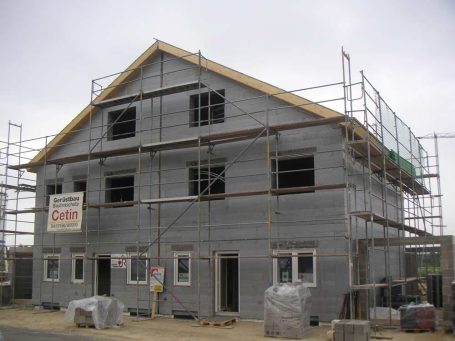 weiter zu Bausatzhaus Hausideen Neues Gebäude im Bau mit Gerüst und offenen Fenstern.